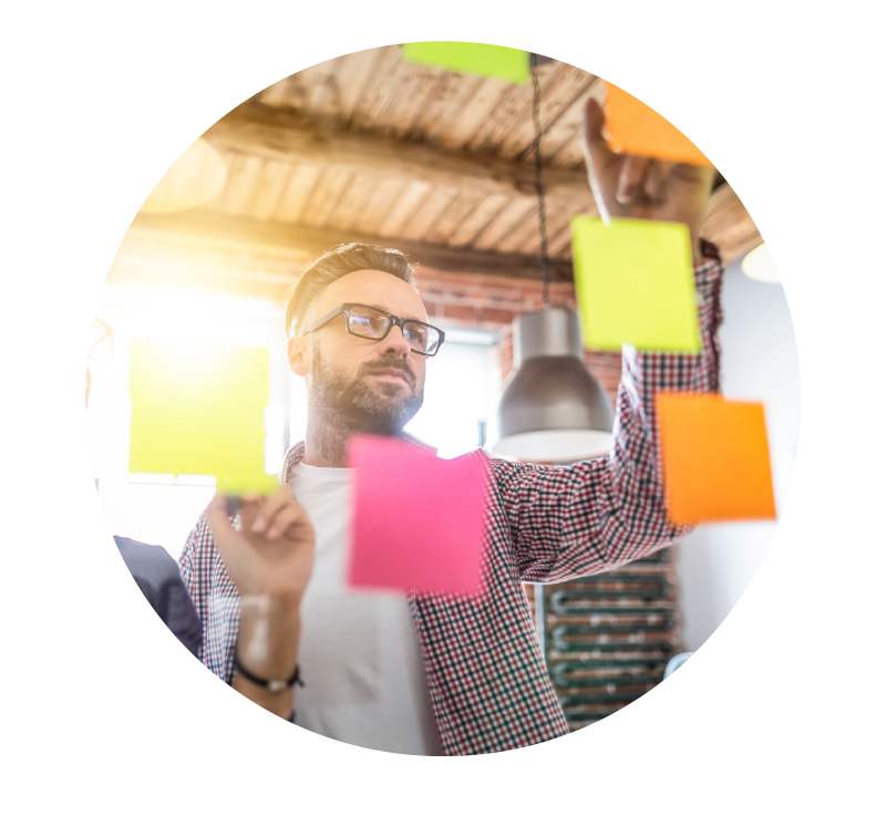 image of a person organizing sticky notes on a wall | Higher Ed Marketing & Student Search Services | enrollmentFUEL