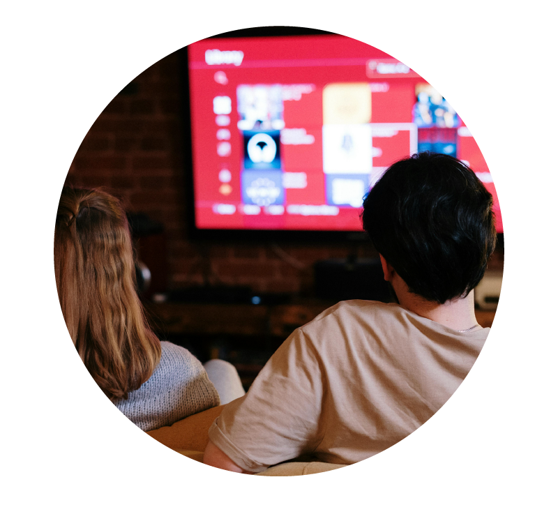 image of two people sitting in front of a television | Higher Ed Marketing & Student Search Services | enrollmentFUEL